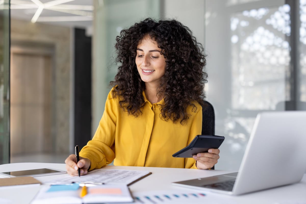 A satisfied financial professional smiling while filling out tax forms